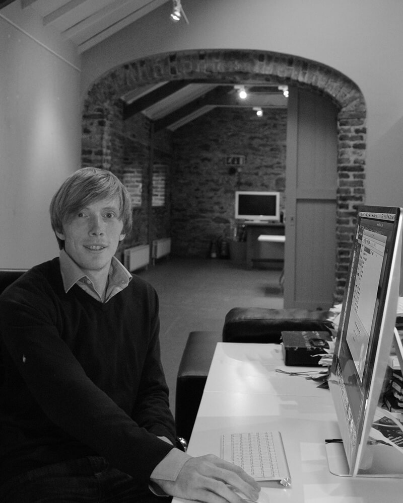 Black and white profile photo sitting at desk.